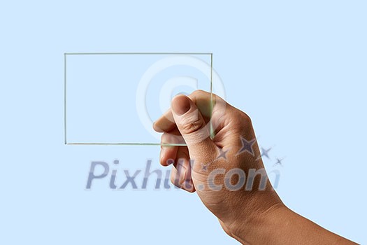 on a blue background a man's hand holds a transparent glass v on a blue background a man's hand holds a transparent glass v