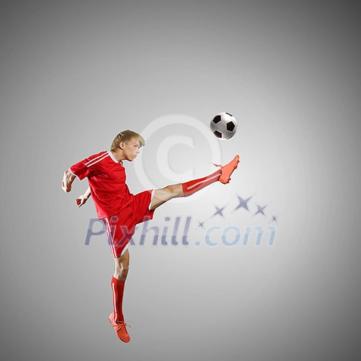 Soccer player kicking ball isolated over white background