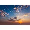 Evening sunset sky with sun and dramatic clouds