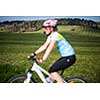 Female mountain biker out of focus with in focus landscape in the distance behind her