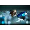 Senior male researcher carrying out scientific research in a lab (shallow DOF; color toned image)