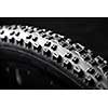 Modern MTB race mountain bike tyre isolated on black background in a studio