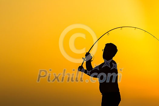 Fisherman silhouette on the beach at colorful sunset