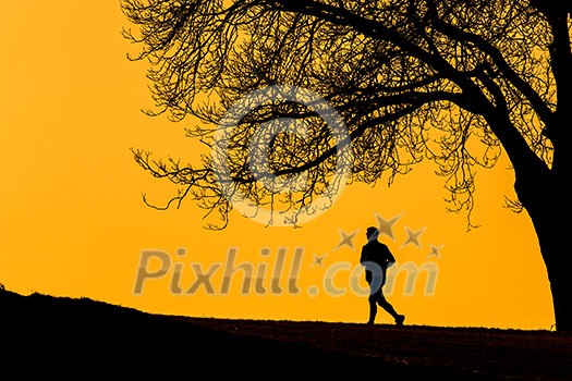Silhouette of a  young man running outdoors on a lovely sunny evening