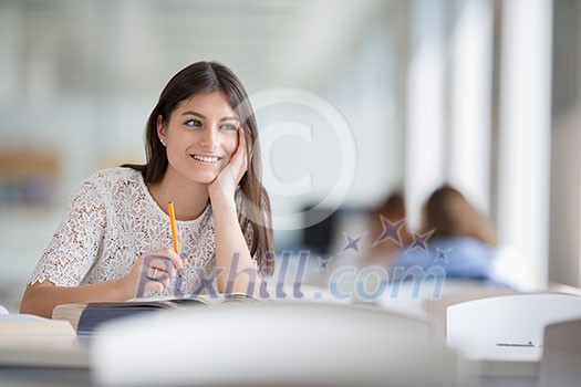 Pretty, young college student looking for a book in the library, studying for her exam