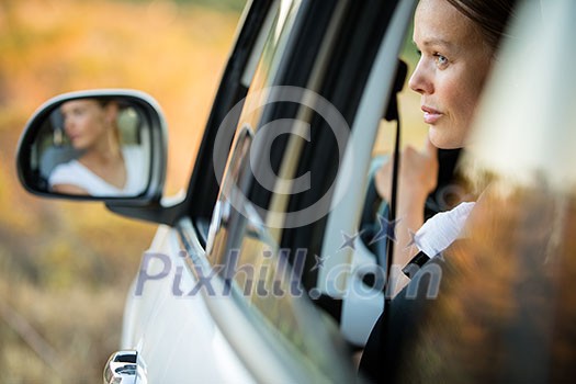 Pretty, young woman  driving her car - reflection in the side mirror (shallow DOF; color toned image)