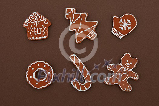 Homemade Gingerbread cookies with different shapes isolated on a brown background. Christmas background