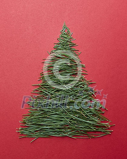 Postcard Happy New Year. Christmas tree pine needles on a red background. Christmas concept.