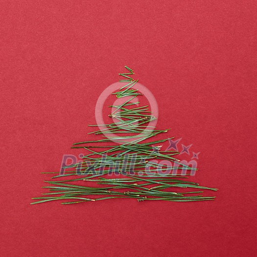 Christmas tree pine needles on a red background. Christmas concept.