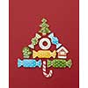 Beautiful Christmas tree made of gingerbread cookies with icing on a red background