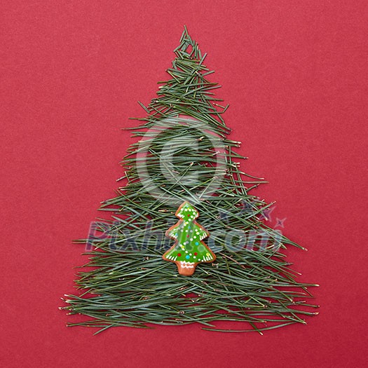 Two Christmas tree on red background. Christmas tree made of pine needles with the decoration of Christmas cookies