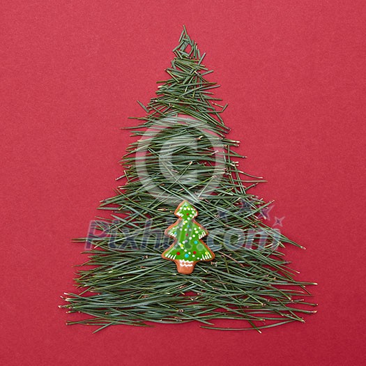 Two Christmas tree on red background. Christmas tree made of pine needles with the decoration of Christmas cookies Two Christmas tree on red background. Christmas tree made of pine needles with the decoration of Christmas cookies