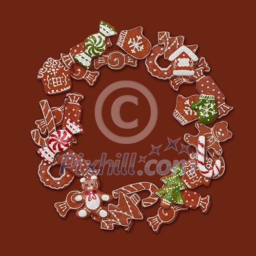 Round frame of homemade gingerbread cookies on a brown background