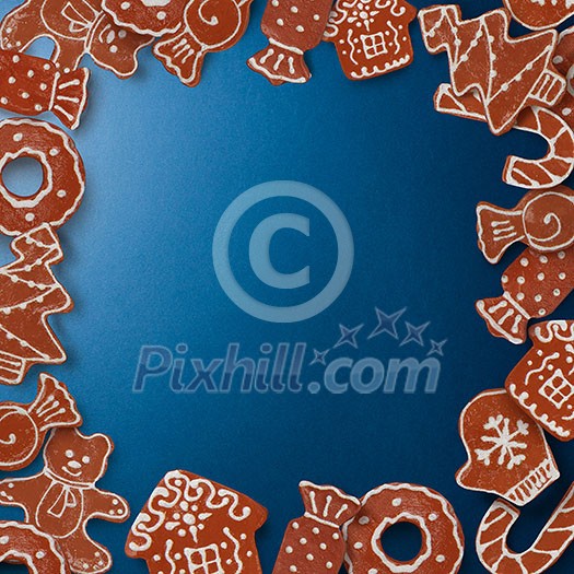 Frame of homemade gingerbread cookies on a blue background