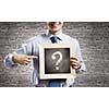 Young smiling businessman holding chalkboard with question sign