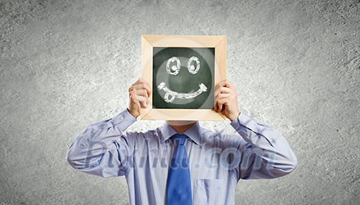 Young smiling businessman holding chalkboard with smiley