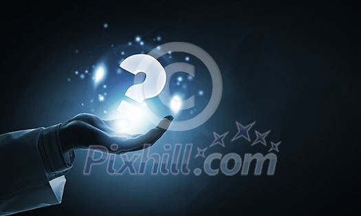 Close up of male hand holding question mark icon Close up of male hand holding question mark icon