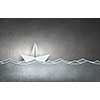Paper ship floating on water on waves