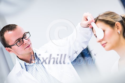 Optometry concept - pretty young woman having her eyes examined by an eye doctor Optometry concept - pretty young woman having her eyes examined by an eye doctor