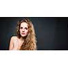 Studio glamour portrait of a pretty, young woman with lovely curly hair