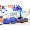 Hands of a female researcher doing research in a lab (shallow DOF; color toned image)