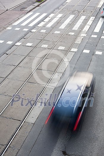 urban traffic concept - city street with a crossing, rail, motion blurred traffic