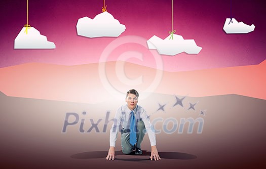 Young determined businessman in starting position ready to compete Young determined businessman in starting position ready to compete
