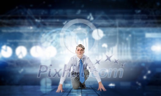 Young determined businessman in starting position ready to compete