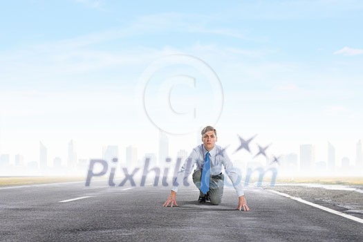 Young determined businessman in starting position ready to compete Young determined businessman in starting position ready to compete