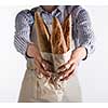 Baker's hands hold fresh bread isolated on white background.