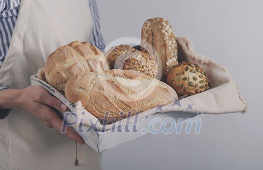 Baker's hands hold fresh bread.