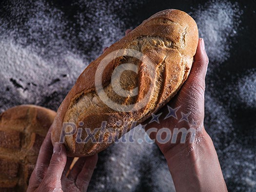 Baker's hands hold fresh bread. Baker's hands hold fresh bread.