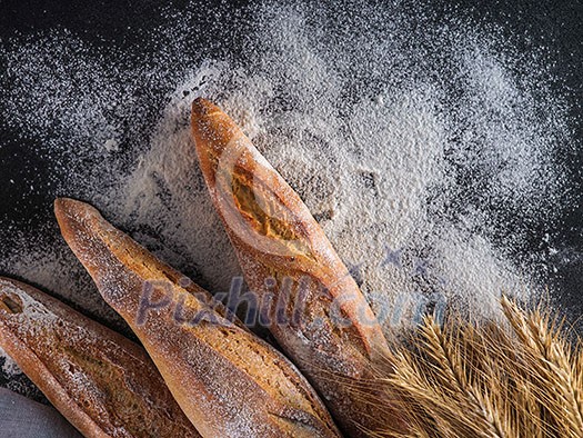 Fresh baguettes on a dark table