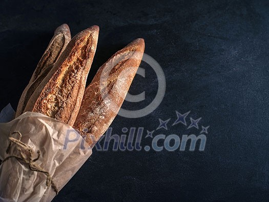 Three freshly baked baguettes on the table Three freshly baked baguettes on the table