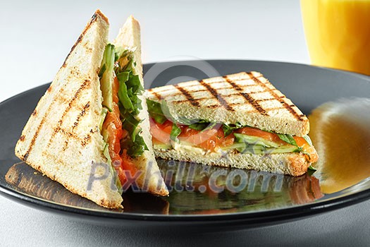 sandwich with salmon and orange juice for breakfast on a table sandwich with salmon and orange juice for breakfast on a table