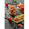 assorted Italian appetizer bruschetta on a dark wooden background