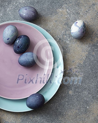 pink and blue plate with Easter eggs hand-made robotic concrete background flat lay
