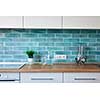 Modern white kitchen at home with utensils on the background of blue tiles