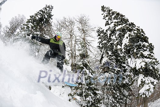 Snowboarder doing a jump and free ride on  powder snow at winter season