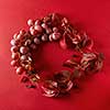 a frame of red grapes and grape leaves on a red background flat lay