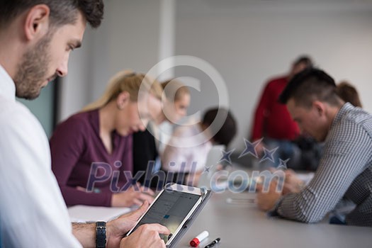 close up of businessman hands using tablet, people group in office meeting room blurred in backgronud close up of businessman hands using tablet, people group in office meeting room blurred in backgronud
