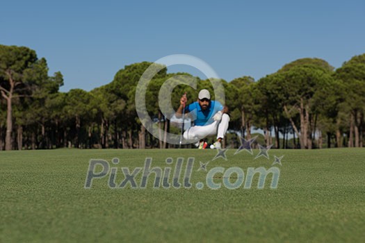 golf player aiming shot with club on course at beautiful sunny day