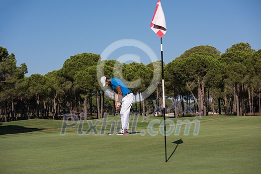 golf player hitting shot with driver on course at beautiful sunny day