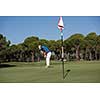 golf player hitting shot with driver on course at beautiful sunny day