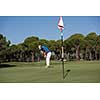 golf player hitting shot with driver on course at beautiful sunny day