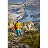 Pretty, young female hiker walking in high mountains (shallow DOF)