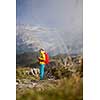 Pretty, young female hiker walking in high mountains (shallow DOF)