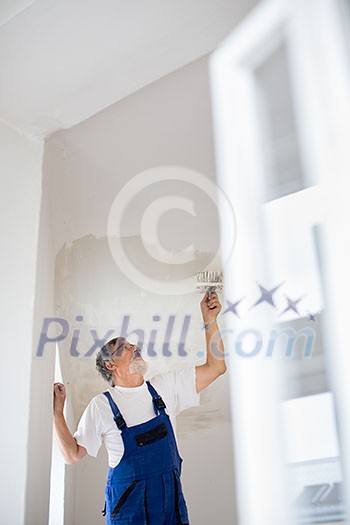 Painter man at work with a paint bucket, wall painting concept Painter man at work with a paint bucket, wall painting concept
