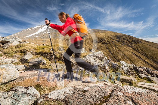 Pretty, young female hiker going uphill Pretty, young female hiker going uphill
