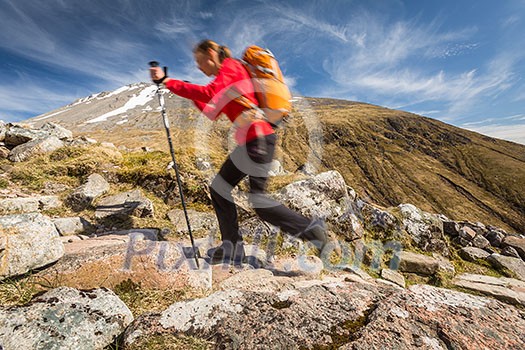 Pretty, young female hiker going uphill